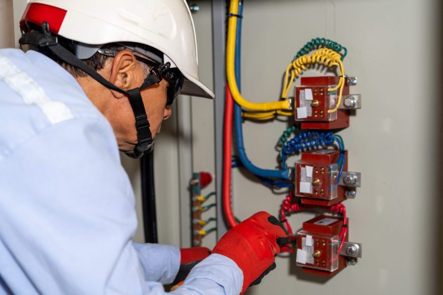 Latin electrical engineer performs maintenance on an industrial circuit